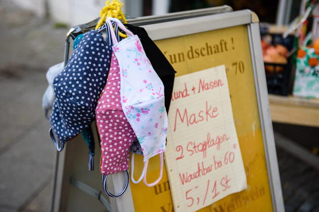 April 23, 2020, Berlin, Berlin, Germany: Hand made, patterned masks for sale hanging over a sales sign in Berlin Schoeneberg. From April, 27 people in Berlin have to wear a face mask in city buses, subway and underground trains. Also in the partly reopened retail sector and in contact with persons at risk, such protection is only strongly recommended. As there is still a lack of respiratory masks and protective equipment among doctors and hospitals, many entrepreneurs offer self-made, non-medical masks for sale. Berlin Germany - ZUMAs172 20200423_zap_s172_025 Copyright: xJanxScheunertx