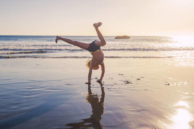 Little boy practicing handstand on the beach model released Symbolfoto IHF00320