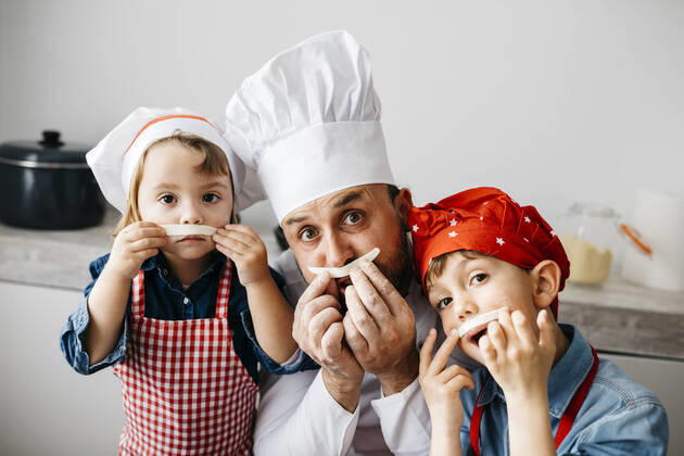Playful father with two kids having fun while preparing homemade pasta in kitchen at home model released Symbolfoto property released JRFF04299