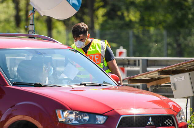 Coronavirus in Bayern, Tests in Bad Reichenhall (200423) -- BAD REICHENHALL (GERMANY), April 23, 2020 (Xinhua) -- A Policeman wearing a face mask checks a vehicle at a checkpoint on the border between Germany and Austria in Bad Reichenhall, southern Germany, on April 23, 2020. The rate of new infections with COVID-19 in Germany continued below peak times as the number of confirmed cases increased by 2,352 within one day to 148,046, the Robert Koch Institute (RKI) announced on Thursday. (Photo by Kevin Voigt Xinhua) GERMANY-BAD REICHENHALL-COVID-19-BORDER CONTROL 