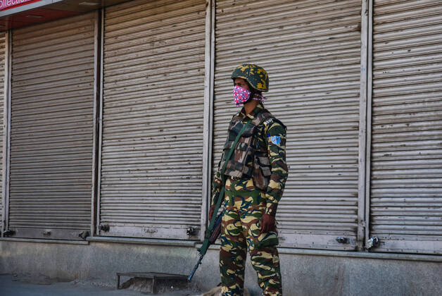 April 24, 2020, Srinagar, Jammu & Kashmir, India: A paramilitary trooper stands in front of a closed shop while wearing a face mask as a preventive measure during the Coronavirus (COVID-19) lockdown Crisis..Curfew like restrictions continued on movement of people to curb the spread of coronavirus in Kashmir valley. 20 new coronavirus cases were reported as on Apr 24, according to officials. This brings the total reported cases of coronavirus in Jammu and Kashmir to 454. Srinagar India - ZUMAs197 20200424_zaa_s197_043 Copyright: xSaqibxMajeedx