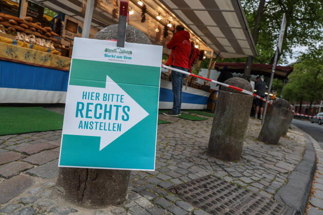 DEU, Germany, North Rhine-Westphalia, Münster, 25 04 2020 Shopping at the weekly market Because of the risk of corona infection, the weekly market has been straightened out so that there are open spaces between stands for waiting customers.