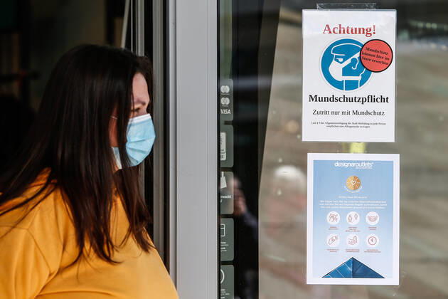 25 04 2020, xtgx, Consequences of the Corona Virus in Wolfsburg, an employee wearing a protective mask stands in front of a sign at Designer Outlet Wolfsburg DOW, Outlet Center In Wolfsburg, it is mandatory to wear a mask that covers mouth and nose in all shops and buses Wolfsburg