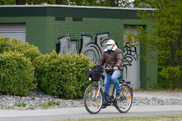 25 04 2020, xtgx, Consequences of the Corona Virus in Wolfsburg, a cyclist with a mask In Wolfsburg, there is an obligation to wear a mask that covers mouth and nose in all shops and buses Wolfsburg