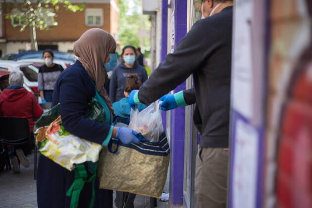 Spain: Food distribution due to Covid-19 crisis A person picks up a bag of food at the Aluche Neighbors Association Madrid Madrid Spain Copyright: FerxCapdeponxArroyo