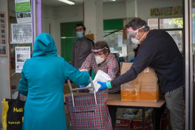 Spain: Food distribution due to Covid-19 crisis A person picks up a bag of food at the Aluche Neighbors Association Madrid Madrid Spain Copyright: FerxCapdeponxArroyo