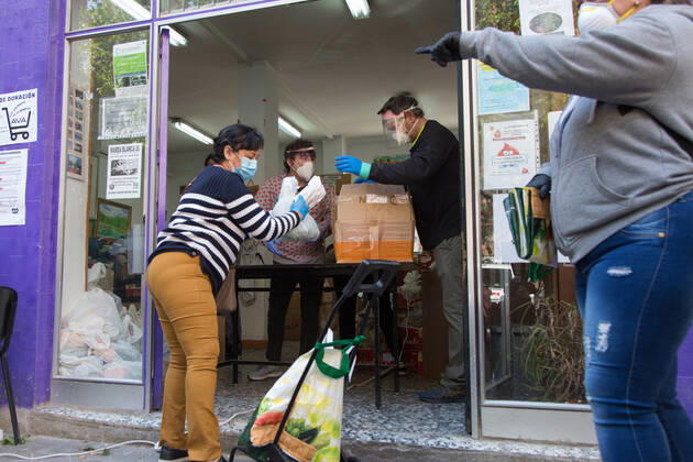 Spain: Food distribution due to Covid-19 crisis A person picks up a bag of food at the Aluche Neighbors Association Madrid Madrid Spain Copyright: FerxCapdeponxArroyo