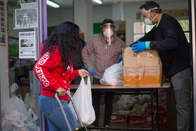 Spain: Food distribution due to Covid-19 crisis A person picks up a bag of food at the Aluche Neighbors Association Madrid Madrid Spain Copyright: FerxCapdeponxArroyo