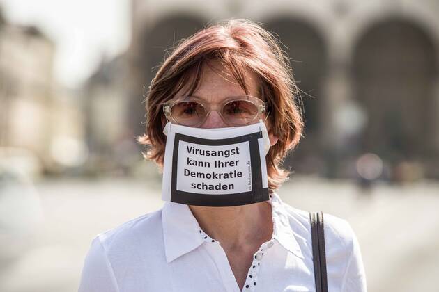 April 25, 2020, Munich, Bavaria, Germany: Virus fears can damage democracy worn by a woman during a conspiracy theorist demonstration in Munich, Germany. Organized in Telegram chats by conspiratorial â€oeQuerfront†(cross-front) groups, the city of Munich, Germany saw numerous anti-state â€oeCorona Parties†as under mottos such as â€oeDemonstration fuer die Erhaltung der Grundrechte†(Demonstration for the Upholding of Basic Rights) and â€oeFuer unsere Freiheit, unsere Grundrechte und unsere Selbstbestimmung†(Demonstration for our Freedom, Basic Rights, and Self-Determination). Numerous right-extremists, Verfassungsschutz-monitored figures, QAnon fans, and AfD politicians were in attendance. The groups are of the belief that the anti-Coronavirus measures are power-grabs. Querfront groups are o - ZUMAb160 20200425_zbp_b160_023 Copyright: xSachellexBabbarx