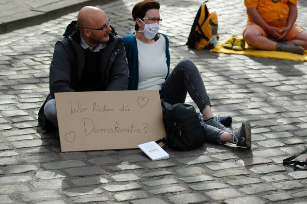 Lockdown immediately end demonstration on Südermarkt in Flensburg The Communication Center Democratic Resistance organizes a demonstration on 25 04 2020 in Flensburg on Südermarkt, downtown Flensburg Two demonstrators sat on the floor, in front of them a banner with the words We love democracy, before that reading the Basic Law