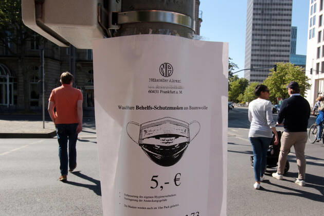 Stop at a traffic light pole with a sales offer of handmade makeshift cotton masks in the city centre of Frankfurt, Hesse, Germany