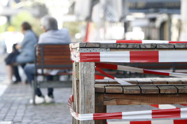 Barrier tape around tables and chairs of a closed restaurant in the city centre of Frankfurt, Hessen, Frankfurt