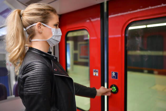 Woman with a face mask, standing in a train, opens doors, corona crisis, Stuttgart, Baden Württemberg, Germany Coronavirus
