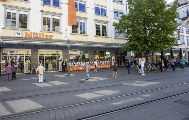 Wuerzburg, City, 27 04 2020, Coronavirus Mandatory masks in Bavaria Picture Big rush at Mueller, customers have to wait in front of the store to comply with the distance regulation, People in Bavaria have to wear a mouth and nose cover when shopping or using public transport, children from 7 years on are also required to wear masks Copyright: HMBxMedia xHeikoxBecker