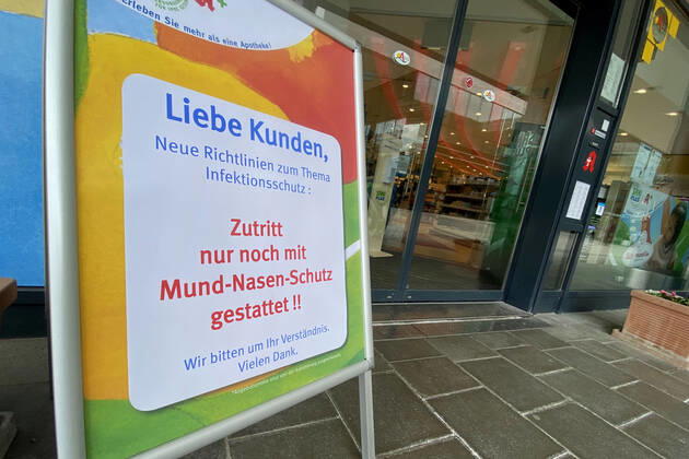 Relaxation and compulsory masks in the coronavirus pandemic Businesses in Bavaria will open again on April 27th with a notice that the display in front of a Sani Plus pharmacy will only allow access with mouth and nose protection,