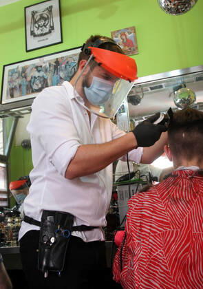 28.04.2020 Belgrade(Serbia) Coronavirus Covid-19 Life loosening measures Friseur hair stylist studio Goca Gotza open after 43 days state of emergency.Friseour hairdresser Nikola working with protection mask,vizir visor made of plexiglass.