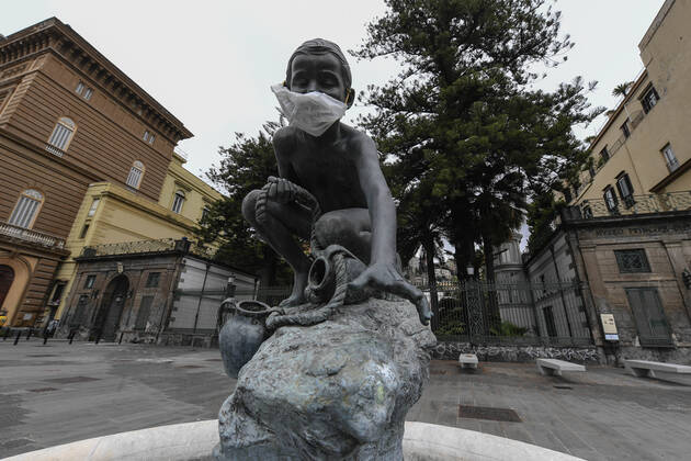 A protective mask is placed on a statue of a child fisherman, in street riviera, in Naples city. Government Decree declaring all of Italy a protected area to combat Covid-19 - Coronavirus infection. Copyright: xSalvatorexLaportax xIPAx xKontrolabx