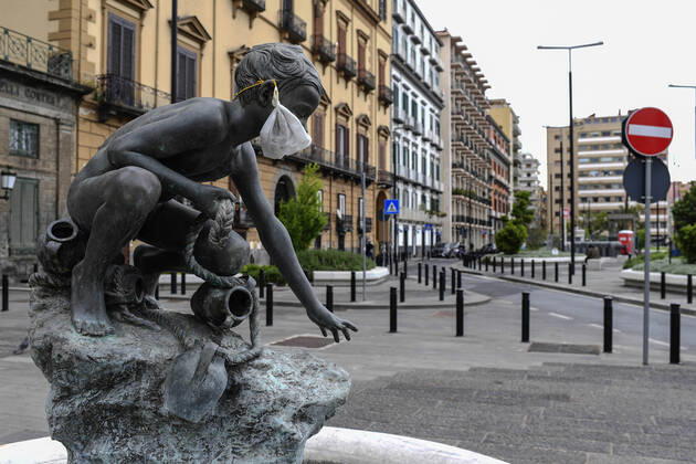 A protective mask is placed on a statue of a child fisherman, in street riviera, in Naples city. Government Decree declaring all of Italy a protected area to combat Covid-19 - Coronavirus infection. Copyright: xSalvatorexLaportax xIPAx xKontrolabx