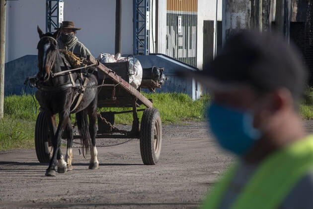 Coronavirus, Eindrücke aus Argentinien April 28, 2020, Firmat, Santa Fe, Argentina: A man using a scarf as face mask and driving a horse-drawn cart crosses the route after passing a check point established on one of three open accesses to the city. The daily life of a little country town has seen a big change due to the COVID-19 outbreak. Firmat Argentina - ZUMAm105 20200428_zaf_m105_006 Copyright: xPatricioxMurphyx