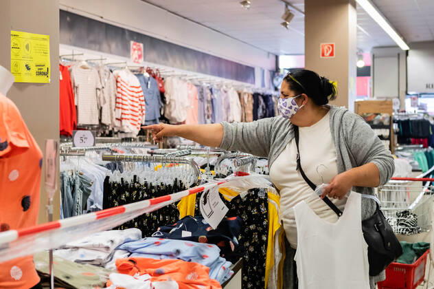 (200430) -- BERLIN, April 30, 2020 (Xinhua) -- A customer wearing a face mask selects clothes at a shop in Berlin, capital of Germany, on April 29, 2020. Berlin made masks mandatory in stores on Wednesday, as the obligation to cover the mouth and nose has already been in force for public transportation since Monday. (Photo by Binh Truong Xinhua) GERMANY-BERLIN-COVID-19-FACE MASK-MANDATORY IN STORES 