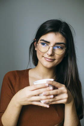 Thoughtful young businesswoman having coffee during break in office model released Symbolfoto property released ABZF03089