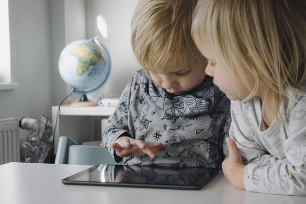 Little boy testing digital tablet while his younger sister watching him model released Symbolfoto property released JOSEF00314