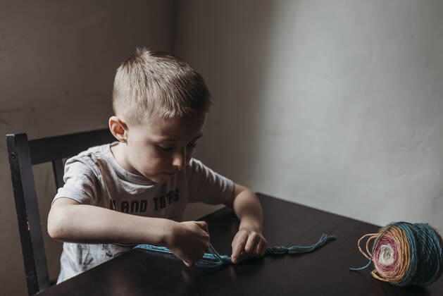 IMAGO Creative: Digitale Welt, Verzicht auf Technologie Young boy knitting with fingers at home during isolation San Diego, CA, United States CR_KESM200409-341162-01,model released, Symbolfoto