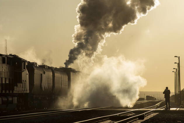 Steam engine smoking heavily moves down track into yellow sunrise Lordsburg, NM, United States CR_MALI200508-354443-01,EDITORIAL USE ONLY