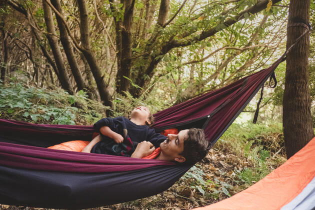 IMAGO Creative: Ende des Sommers A man and a young kid lying in a hammock in the forest Santa Cruz de Tenerife, CN, Spain CR_SEVI200402-201054-01,model released, Symbolfoto