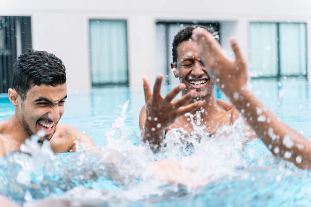 IMAGO Creative, Jahreszeit Sommer, Sommerferien Man smiling as he plays in a circle with a group of friends in a pool Kuching, Sarawak, Malaysia CR_TECM200409A-341665-01,model released, Symbolfoto