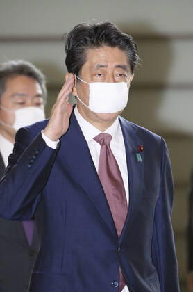 Japan PM Abe Japanese Prime Minister Shinzo Abe arrives at his office in Tokyo on June 4, 2020, wearing a face mask amid continuing worries over the novel coronavirus.