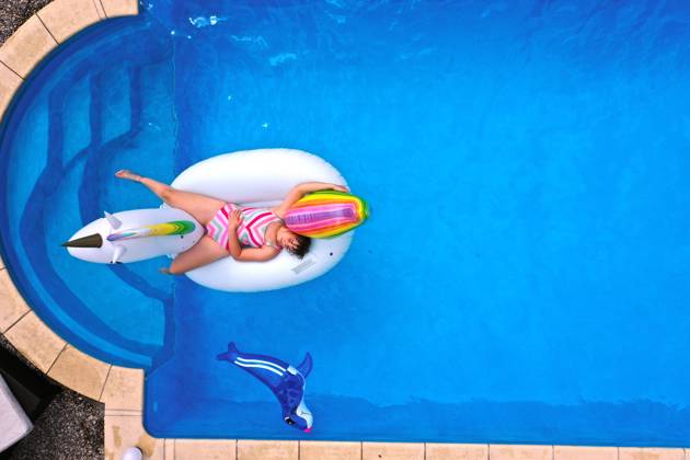 26 06 2020, Trend in the Corona Pandemic The own swimming pool in the garden provides refreshment in summer when the outdoor pools are closed Aerial view of a garden pool in Unterallgäu Teenager swimming in the water on a rubber Unicorn Modelreleased 26 06 2020, swimming pool in own garden 26 06 2020, swimming pool in own garden
