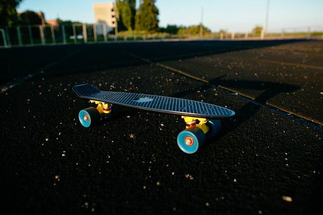 Black penny skateboard on the black sport field. Copyright: xazovtcev161x Panthermedia27280515 ,model released, Symbolfoto
