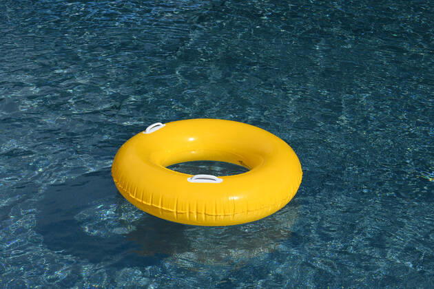Symbolic image of an open-air swimming pool a yellow swimming tire floating on the surface of a swimming pool, Löffingen, Baden Württemberg, Germany