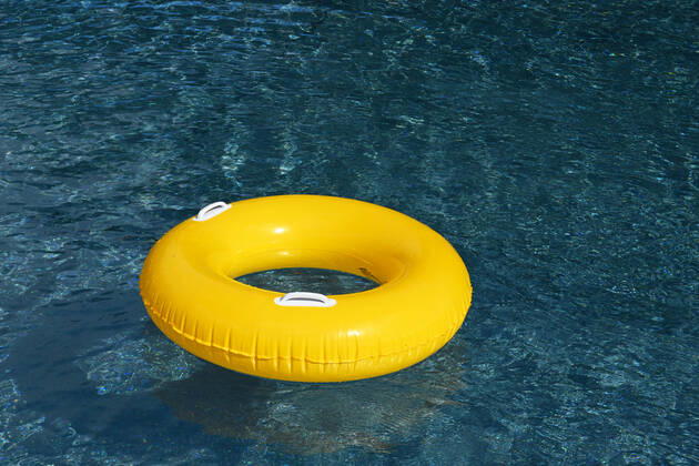 Symbolic image of an open-air swimming pool a yellow swimming tire floating on the surface of a swimming pool, Löffingen, Baden Württemberg, Germany