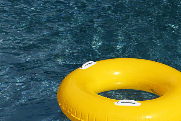 Symbolic image of an open-air swimming pool a yellow swimming tire floating on the surface of a swimming pool, Löffingen, Baden Württemberg, Germany