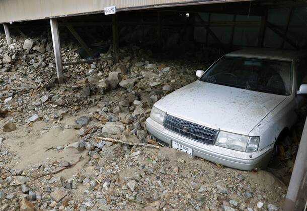 Torrential rain in central Japan Photo taken July 9, 2020, shows a car half-buried in mud in Gero in Gifu Prefecture, central Japan, after torrential rain.