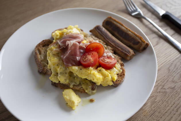 Close up of fresh scrambled eggs on toast with tomato and sausages Zeeland, NB, Netherlands CR_GAWA200701-425607-01