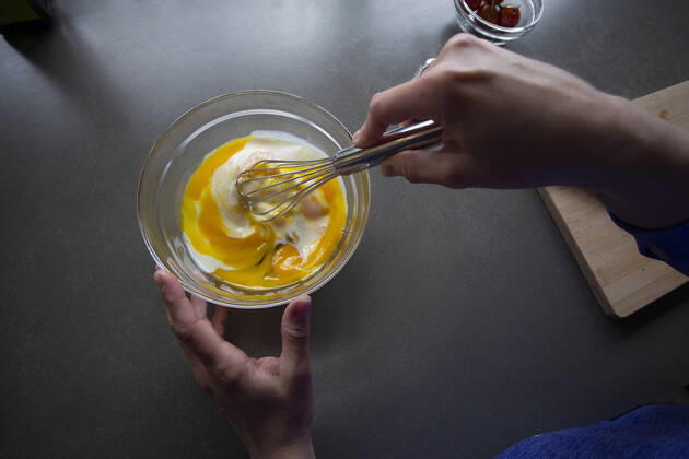 Overhead view of someone whisking milk into eggs in a bowl. Zeeland, NB, Netherlands CR_GAWA200701-425663-01