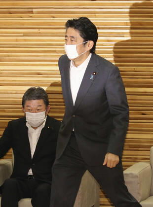 Japan PM Abe Japanese Prime Minister Shinzo Abe attends a Cabinet meeting at his office in Tokyo on July 31, 2020. Seen on the left is Foreign Minister Toshimitsu Motegi.