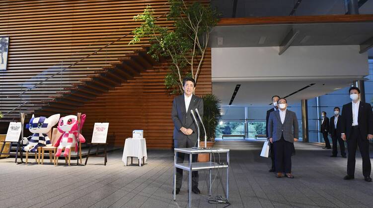 Japan PM Abe Japanese Prime Minister Shinzo Abe (C) speaks to reporters at his office in Tokyo on July 31, 2020.