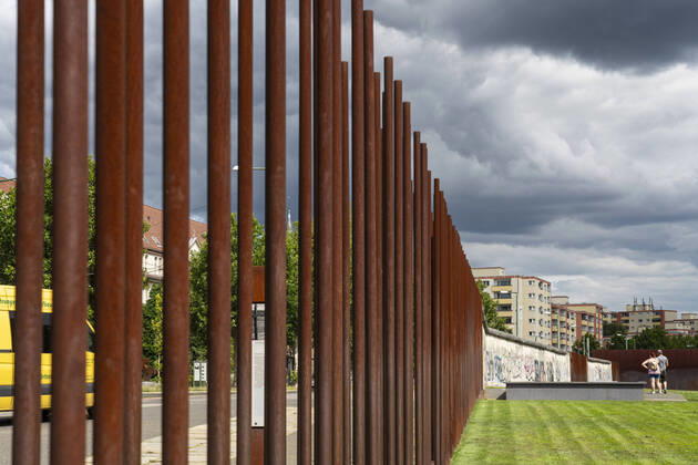 Tourists at the Berlin Wall Memorial on Bernauer Strasse in Berlin Prenzlauer Berg Rusty iron pipes mark the course of the border between East and West Berlin Photo Volker Hohlfeld Berlin Wall Memorial