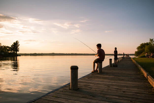 IMAGO Creative, Jahreszeit Sommer, Sommerferien Boys fishing on the dock of a lake at sunset in Ontario, Canada. Kingston, ON, Canada CR_DOHO200803D-455967-01 ,model released, Symbolfoto