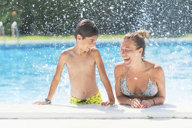 Shirtless boy looking at mother laughing in swimming pool model released Symbolfoto DLTSF00905