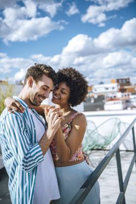 Happy multi-ethnic couple dancing on penthouse patio model released Symbolfoto property released EHF00608