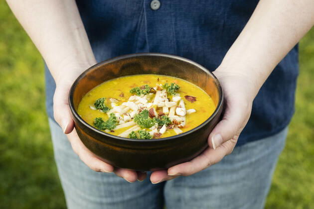 Mans hands holding bowl with dal of lentils, potatoes and vegetables model released Symbolfoto EVGF03632