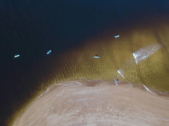 IMAGO Creative: Sommer Sport - Strand Aerial view of people surfing in coastal waters of Barents Sea model released Symbolfoto KNTF04949