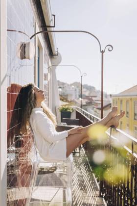 Serene young woman relaxing on sunny apartment balcony, Lisbon, Portugal  Copyright: AlexandraxC.xRibeiro fStopImages1935010 ,model released, Symbolfoto ,property released