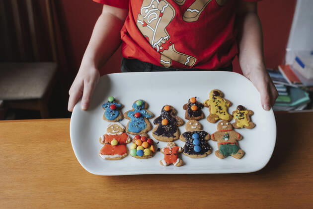 Front view of a girl showing her decorated gingerbread on a plate Hawera, Taranaki, New Zealand CR_LVBS200923-487941-01 ,model released, Symbolfoto