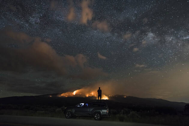 Man looking at wildfire while standing on off-road vehicle against star field Basalt, CO, United States CR_BRHU200930-501991-01 ,model released, Symbolfoto